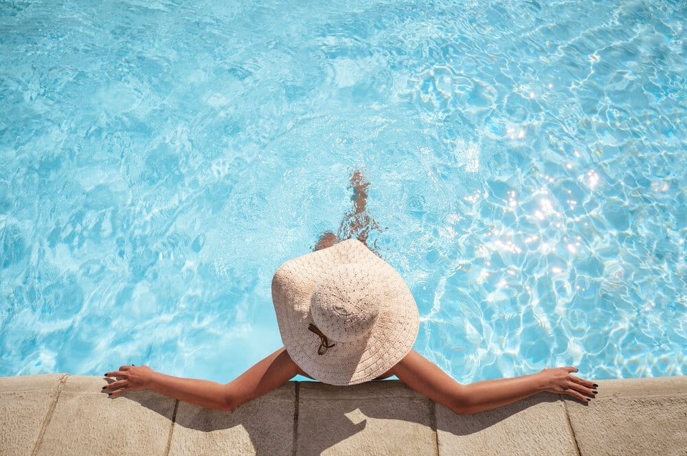 Young woman relaxing in the swimming pool with copy space